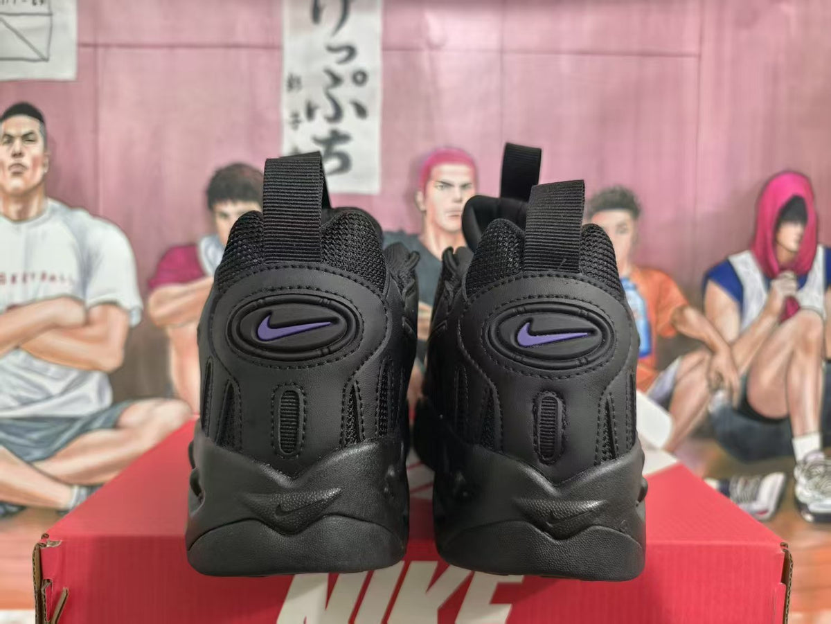 Rear view of black Nike sneakers with purple logos, pull tabs, and a red Nike shoebox.