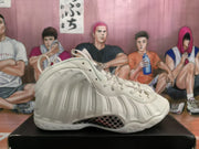 Side profile of a white high-top sneaker showing the sculpted upper and textured midsole area.