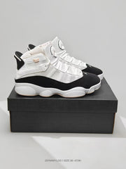 Pair of white, black, and pink-accented Jordan sneakers displayed on a black shoebox.