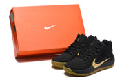 Black Nike sneaker pair displayed beside an orange Nike shoebox.