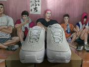 Front view of white Nike sneakers showing the perforated toe areas, laces, and layered upper panels.