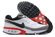 Side view of white, grey, black, and red Nike Air Max sneakers, including the outsole.
