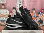 Angled view of black and white Nike basketball sneakers showing the side Swoosh, heel branding, '001' marking, and traction outsole.