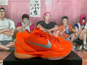 Side view highlighting the textured orange upper, silver Nike Swoosh, and translucent outsole details.