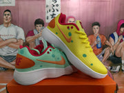 Angled view of the mismatched sneaker pair, showing the yellow and mint green uppers, orange Swooshes, red lining, and white soles.