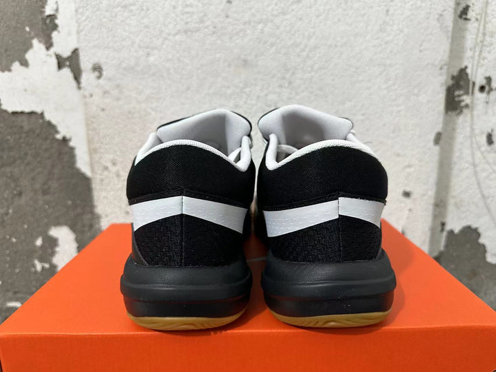 Rear view of black Nike sneakers with white heel accents and gum-colored outsoles
