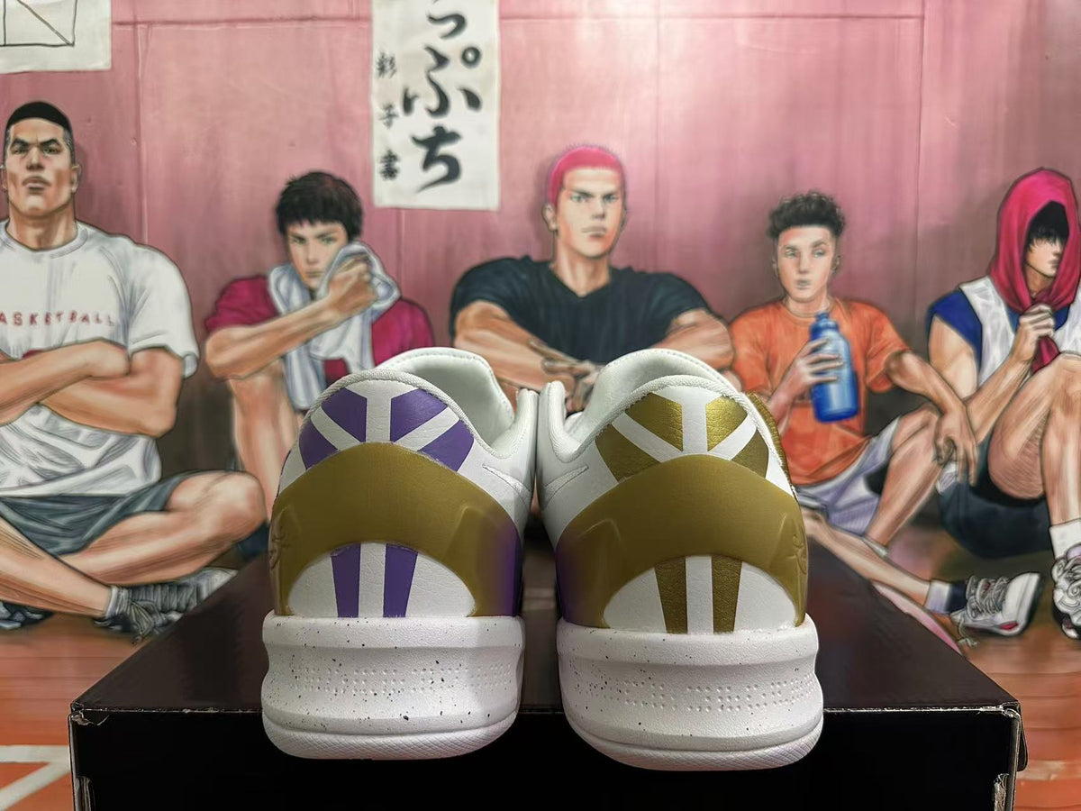 Rear view of white basketball shoes with purple and gold heel details and a speckled midsole