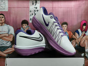 Angled view of Nike basketball shoes showing Swoosh details and purple outsoles
