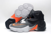 Nike high-top basketball shoes shown from the side with the patterned outsole and orange midfoot accent visible.
