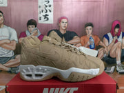 Side profile of a khaki Nike sneaker showing layered stitched panels, Swoosh branding and a white sculpted sole.