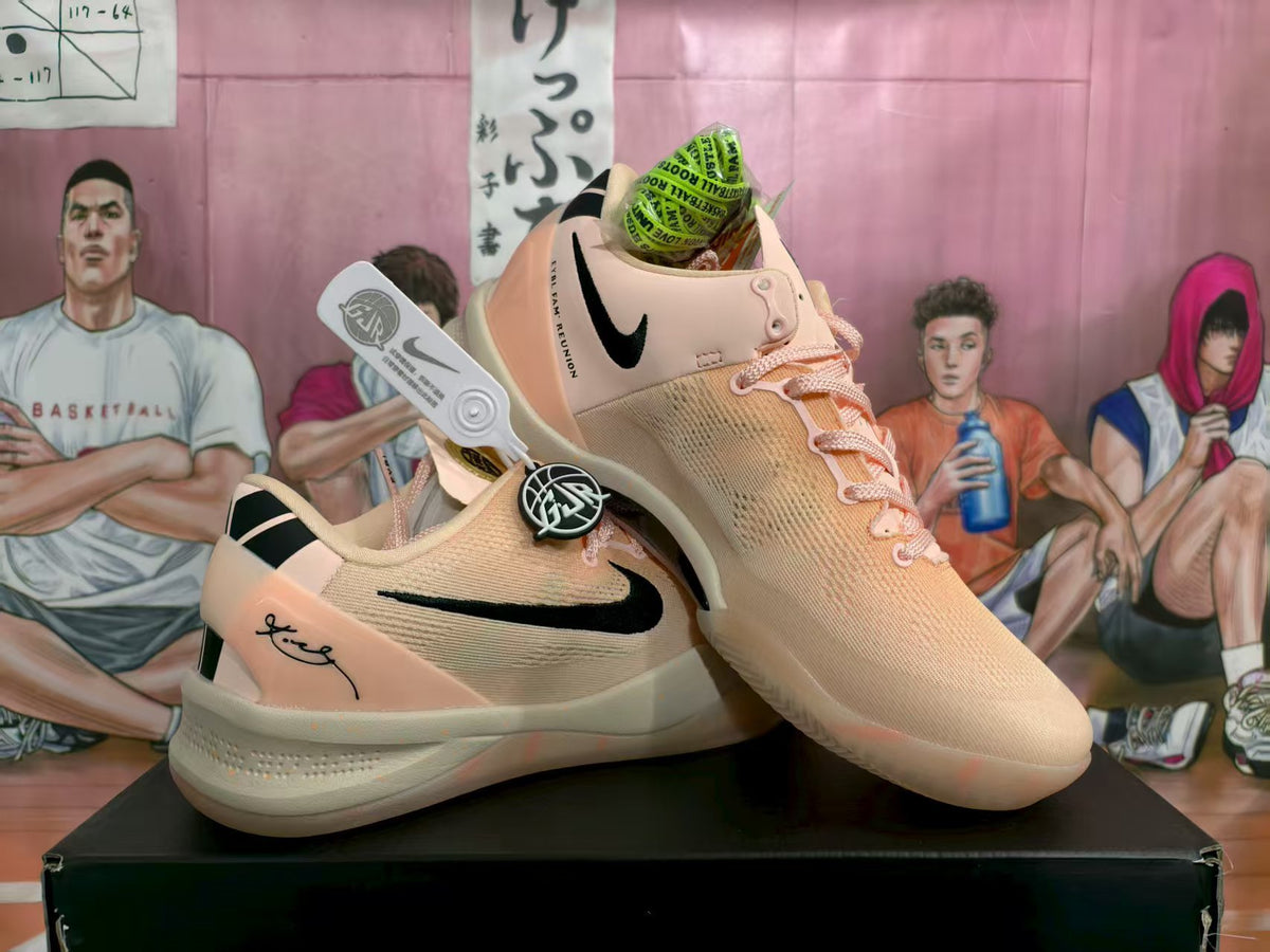 Pair of pink Nike basketball sneakers shown from an angled side view on a black box.