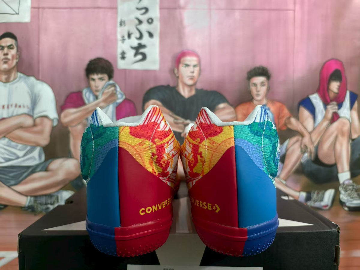 Rear view of mismatched Converse sneakers with blue, green, red and yellow panels and contrasting blue and red outsoles.