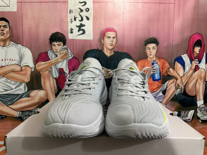 Front view of gray basketball shoes with black and neon yellow accents