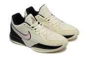 Angled front view of the cream, black and pink basketball sneakers