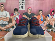 Front view showing navy blue uppers, red laces, and cream-colored outsoles.