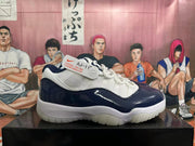 Side view of a navy and white low-top sneaker with a Jumpman logo and a security tag.