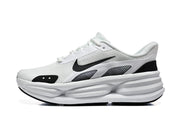 Side view of a white Nike sneaker with black Swoosh and sculpted sole