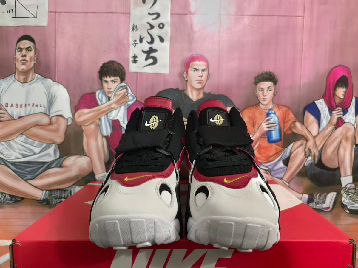 Front view of white, red, and black Nike Air sneakers with black laces and a wide lace strap.