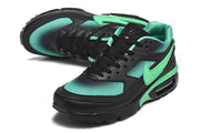 Angled view of a black and mint-green Nike Air Max sneaker.