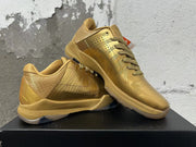 Pair of gold Nike Kobe 5 basketball shoes shown at an angle