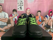 Front view of a pair of black Kobe basketball shoes with textured uppers and green laces