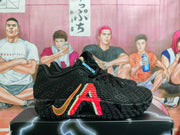 Side profile of a black Nike basketball sneaker showing the orange Swoosh, red side graphic and textured outsole.