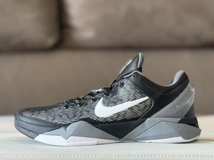 Side profile of a black, grey and white Nike Kobe 7 sneaker with a striped upper and white Swoosh.