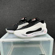 Pair of white, black, and red Jordan low-top basketball shoes shown at an angle.