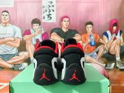Rear view of black Jordan shoes with red collar accents and red heel logos