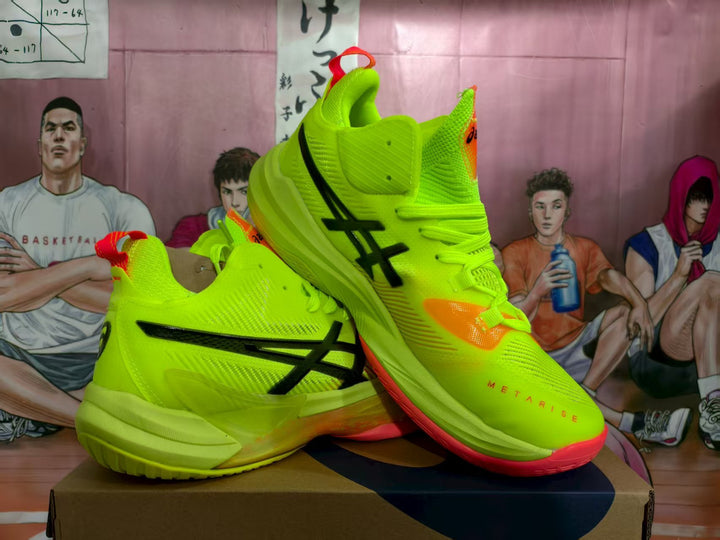 Pair of fluorescent green ASICS basketball shoes shown from the side, with black branding, orange accents and red outsole sections.