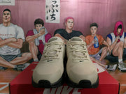 Front view of beige and black Nike Air Max sneakers with lace-up closure and black toe accents.