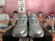 Front view of silver Nike sneakers showing the lace-up design, padded tongues, and textured toe areas.