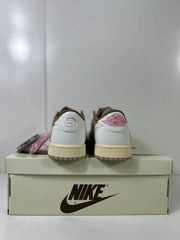 Rear view of low-top sneakers placed on a branded shoebox, showing white heel panels, pink heel graphics, brown collars, and cream midsoles.