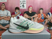 Side view of a Nike basketball shoe with a black Swoosh, teal accents, and pale lime details.