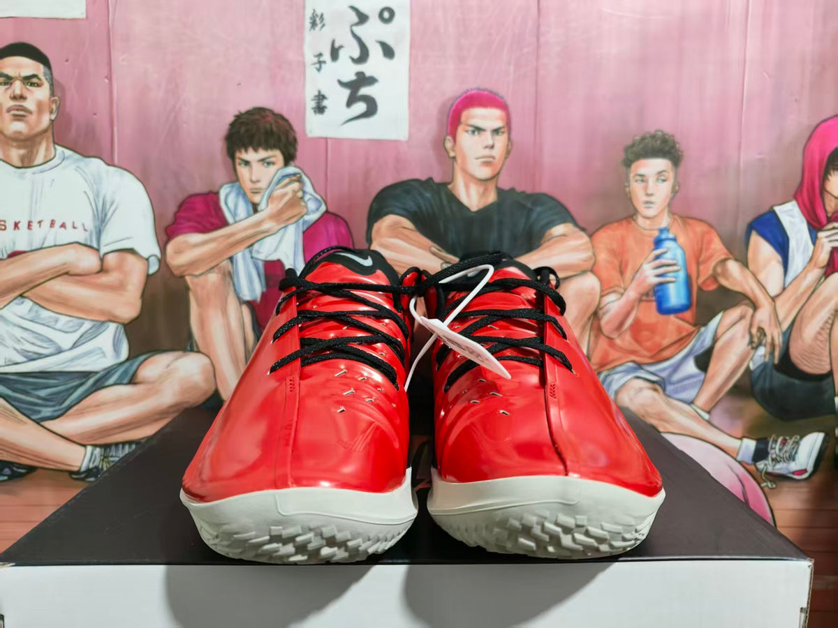 Front view of red and black basketball sneakers with black laces and white textured outsoles.