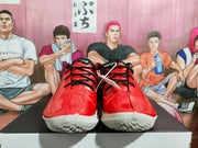 Front view of red and black basketball sneakers with black laces and white textured outsoles.