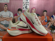 Angled view of the pair highlighting the white upper, red detailing, and low-top design.