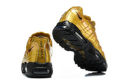 Rear and outsole views of gold-tone Nike Air Max 95 TT sneakers with black soles.