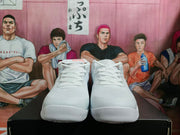 Front view of the white Nike basketball sneakers with matching laces and textured toe areas.