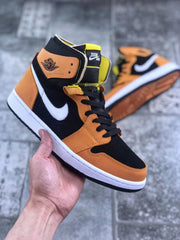 Front three-quarter view showing the black toe box, orange overlays, black laces, and Zoom Air tongue label.
