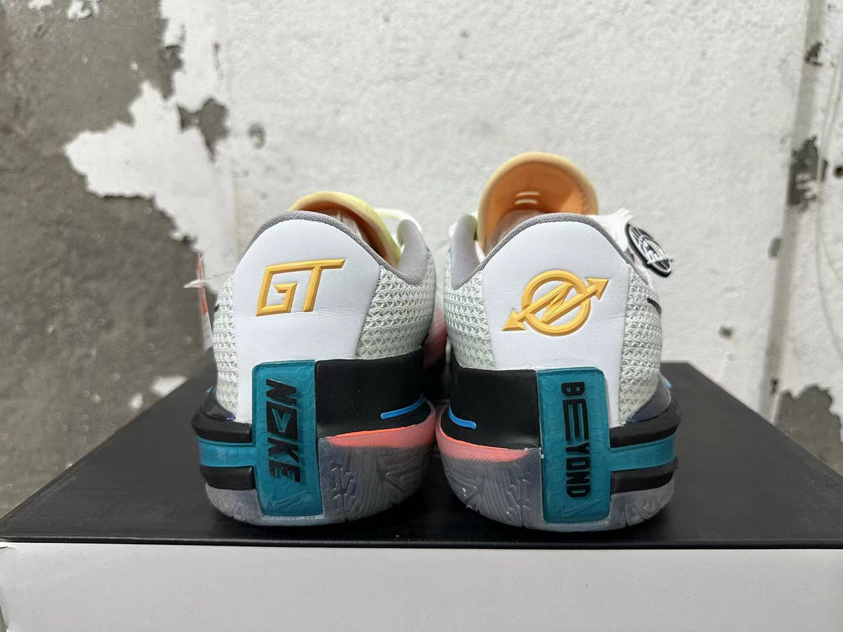 Rear view of white Nike basketball shoes with blue and black heel details and gold markings.