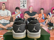 Rear view of gray and black low-top sneakers with white heel branding and cream-colored outsole edges.