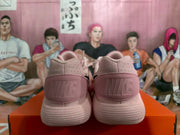 Rear view of pink Nike sneakers showing embossed heel branding and textured soles.