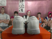 Rear view showing perforated heel panels and sculpted soles on white and grey Nike shoes.