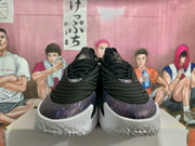 Front view showing the black laces, purple toe panels, and white textured outsole.