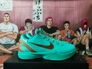 Side view showing the turquoise textured upper, metallic gold Swoosh, laces, padded collar, and Zoom-marked midsole.