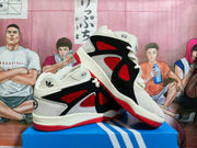 Side and angled view showing the sneakers' black overlays, red inset panels, white upper and red outsole.