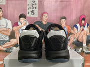 Rear view of black and white Jordan sneakers with red accents, displayed on a shoebox.