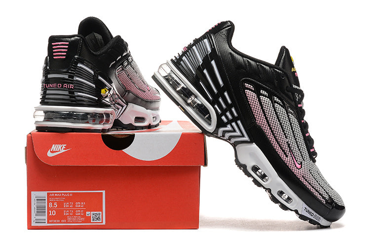 Black, white, and pink Nike Air Max Plus sneakers displayed with a red shoe box; the box label shows size markings.