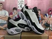 Angled view showing the black and white sneakers, side swoosh, laces, and sculpted outsole.